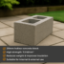 Hollow 215mm concrete block with small twin cavities placed on a paved patio, with neatly trimmed grass and a timber sleeper border in the background. Captured in natural daylight with soft garden surroundings.