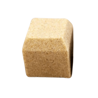 Close-up of a single light buff-coloured block paving brick with a smooth, chamfered edge and fine-textured surface, displayed against a plain white background